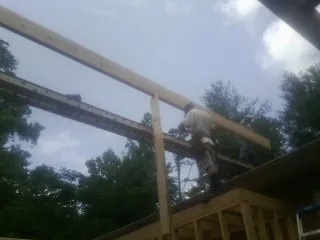 Carpenter setting a ridge beam over a new addition frame — Ice Dam Removal by Roofing Brothers in Green Lake