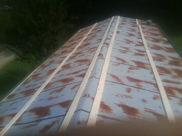 Rusted metal roof panels with new wood purlins before replacement — Storm Damage Roof Repair in Green Lake by Roofing Brothers