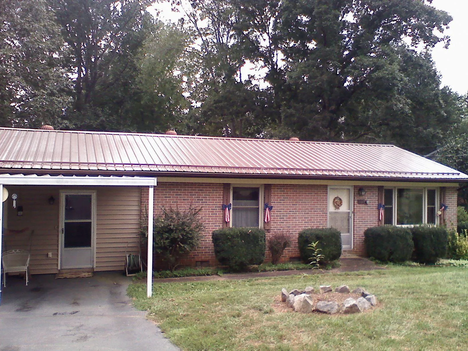 Bronze metal roof and carport on a brick ranch home — Roof Repair work by our crew in Green Lake