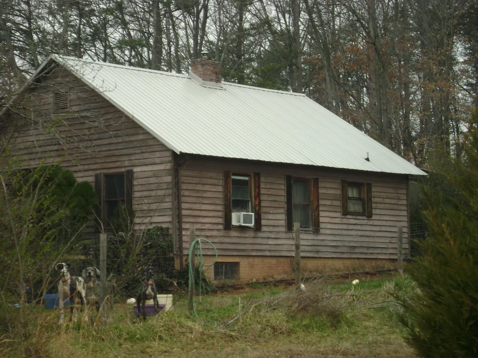 White metal roof on an old wood sided farmhouse, from a Metal Roof Installation job in Green Lake